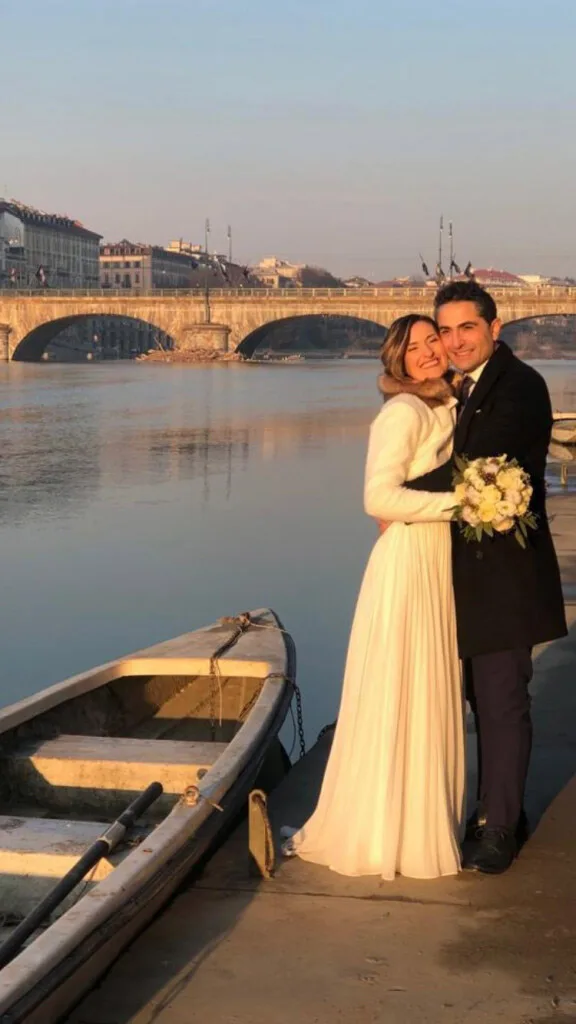 Sposi sulle rive del Po a Torino, con il ponte alle spalle: abito da sposa bianco a vita alta