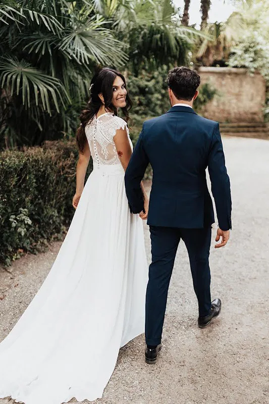 Sposa di spalle che si volta: abito da sposa con schiena in pizzo e bottoncini